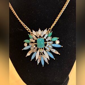 Necklace with large pendant. Gold toned. Adjustable length 18” to 20”.